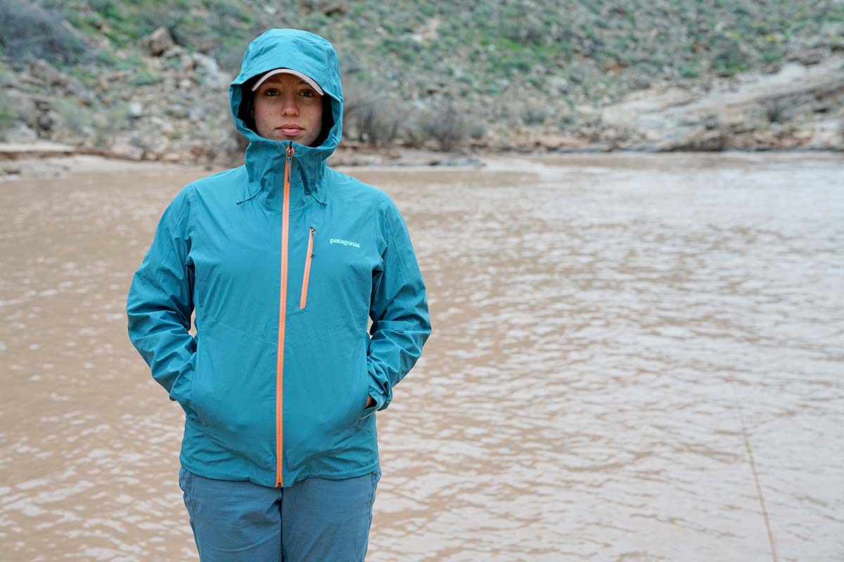 Woman standing in Patagonia Calcite rain jacket beside Colorado River