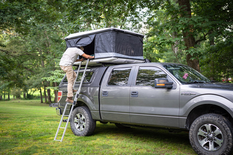 The James Baroud Odyssey on a truck with a man climbing up the ladder