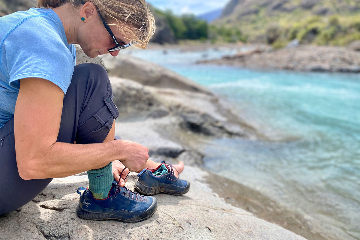 Approach shoe (lacing up Arc'teryx Konseal FL by river)