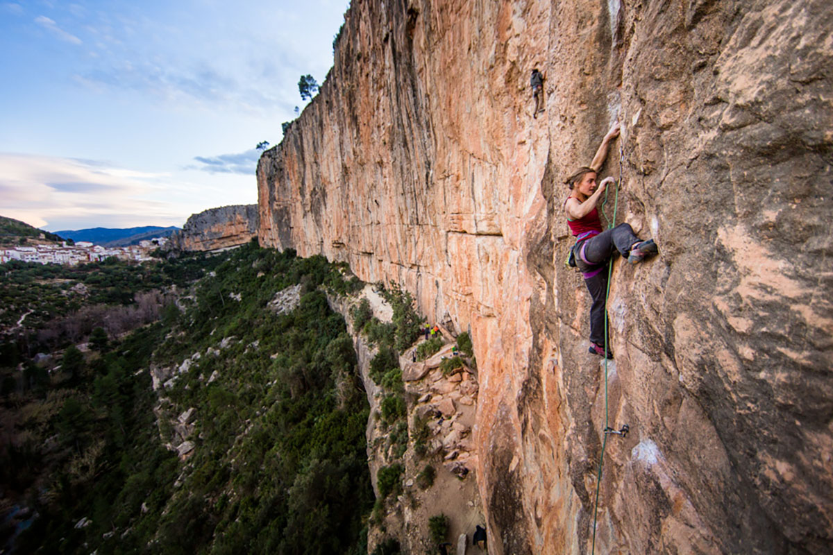 Clipping quickdraw on limestone (sport climbing in Spain)
