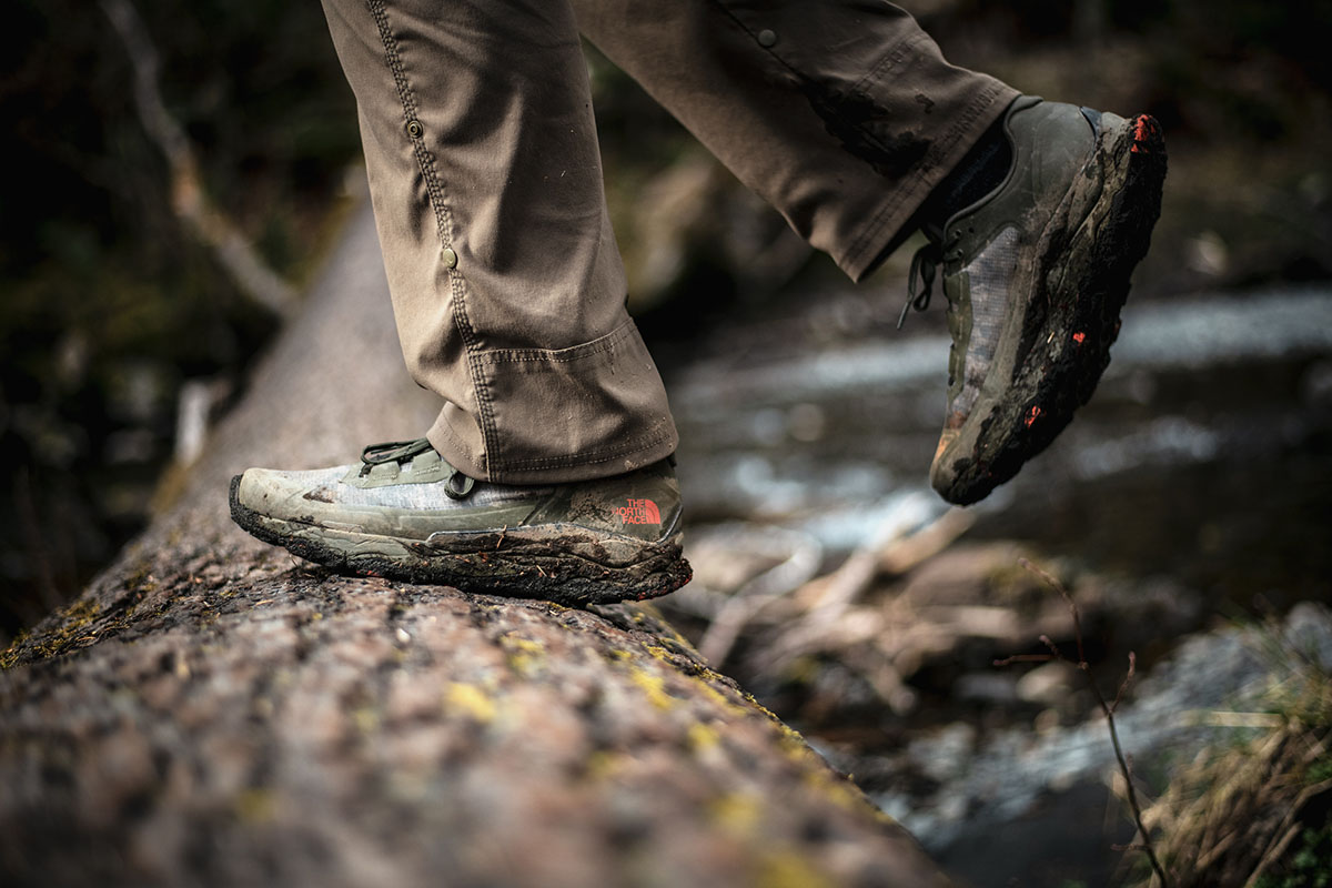 Hiking shoe (The North Face Vectiv Exploris stepping on log)