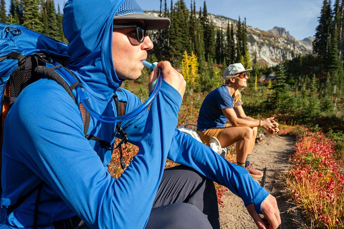 Drinking from CamelBak Crux while sitting on side of trail