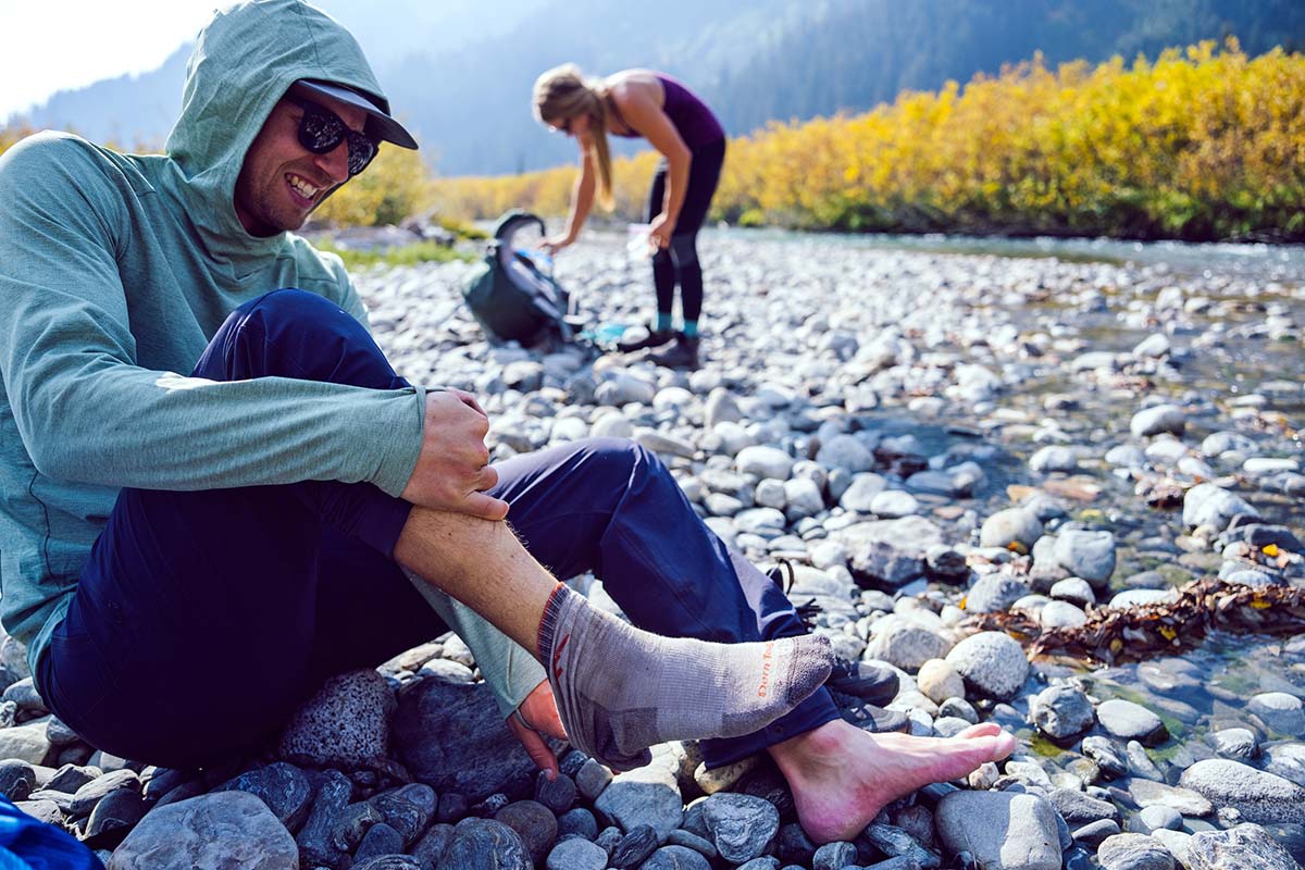 Taking off socks at river (sun shirts)