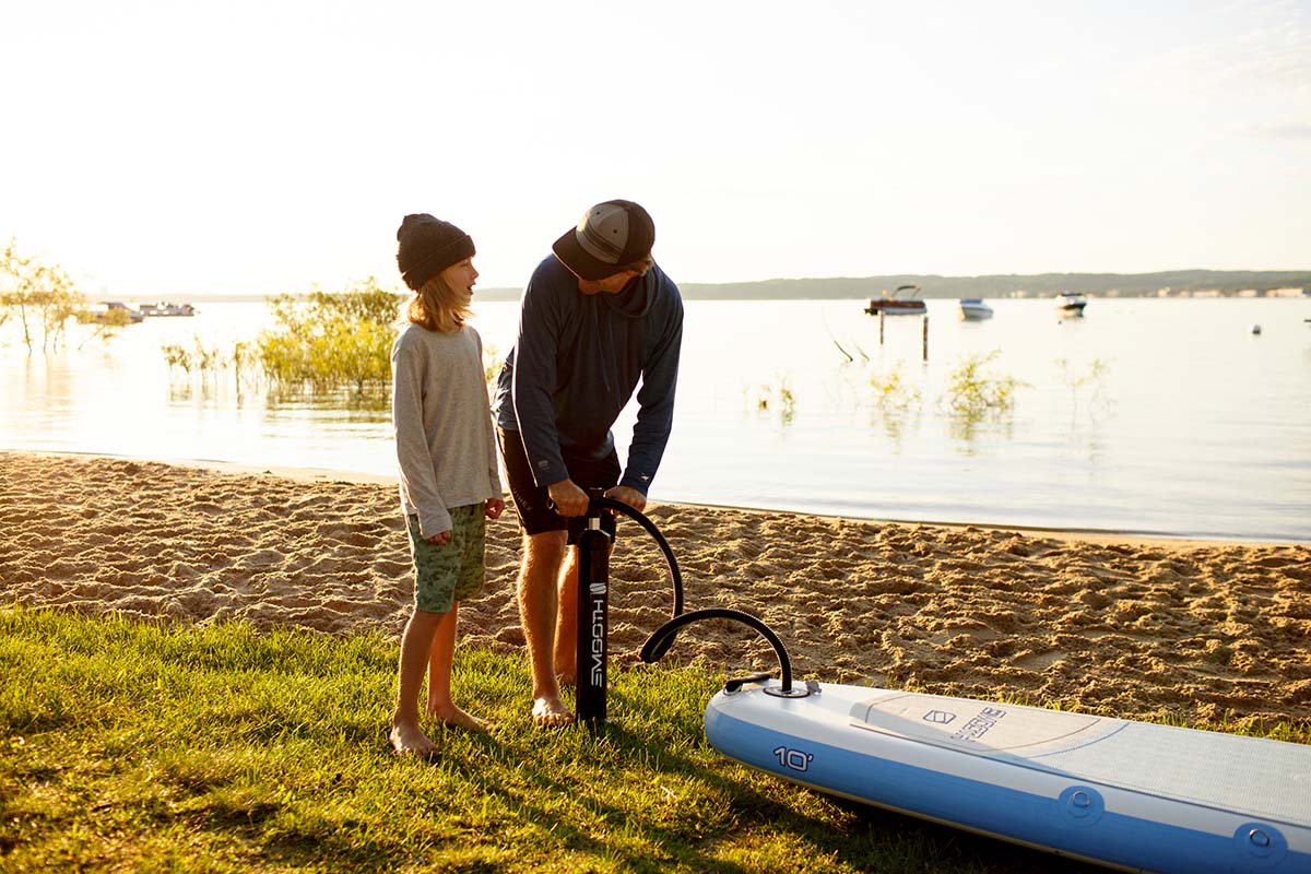 Father and son pumping inflatable SUP