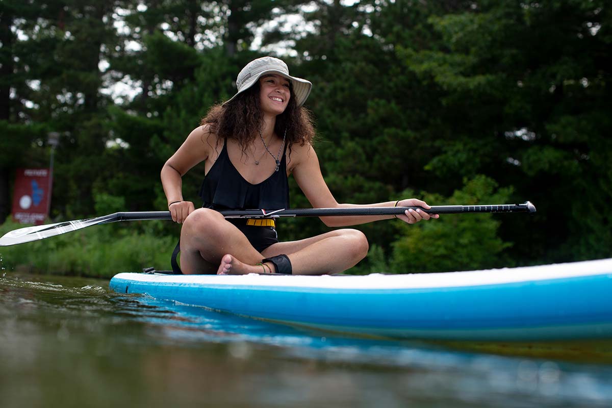 Sitting and smiling on Body Glove SUP (stand up paddle board)