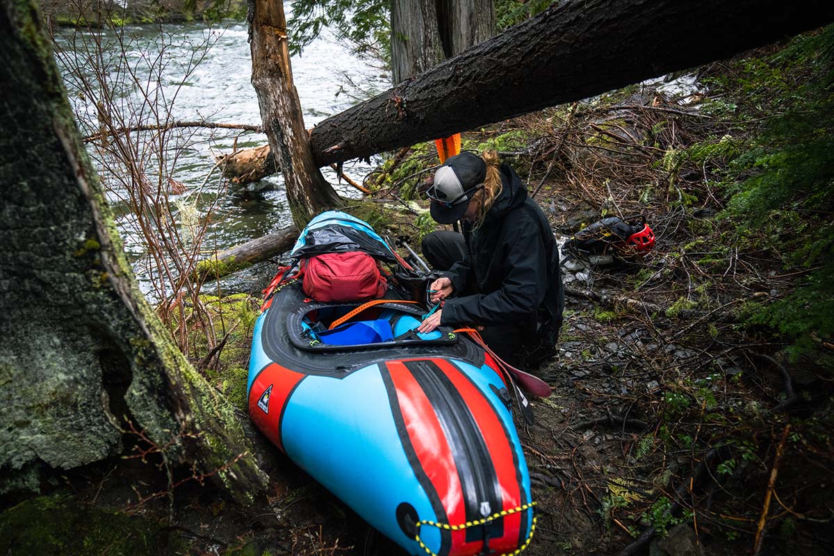 Attaching skis to packraft in forest