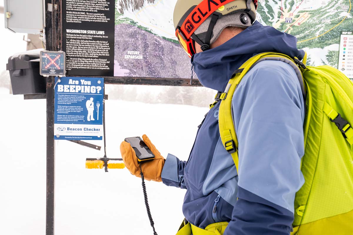 Checking avalanche beacon at resort sidecountry access