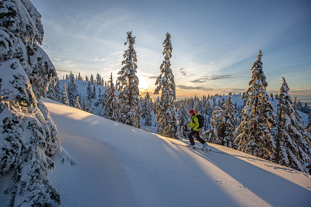 Skinning up hill at sunset (backcountry ski boots)