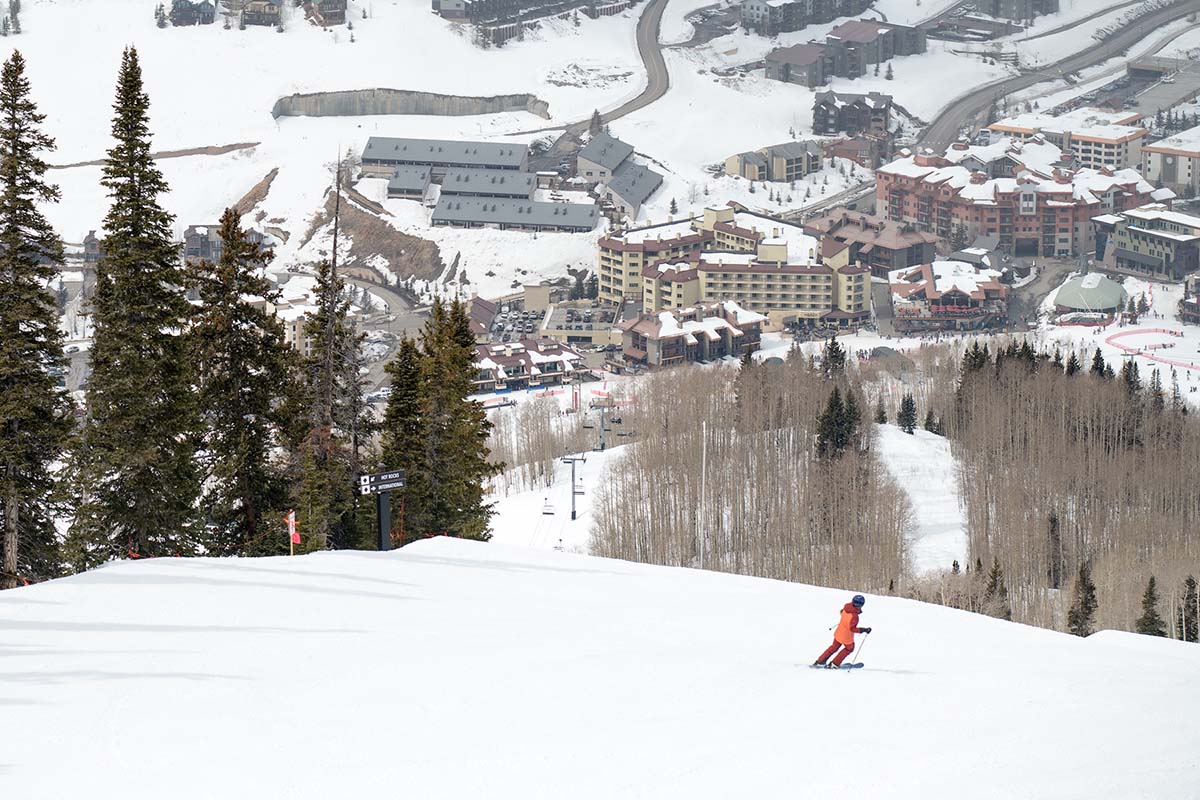 Skiing towards resort on groomer