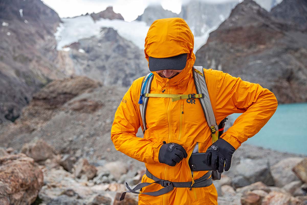 Putting phone into pocket on Outdoor Research Helium AscentShell hardshell jacket