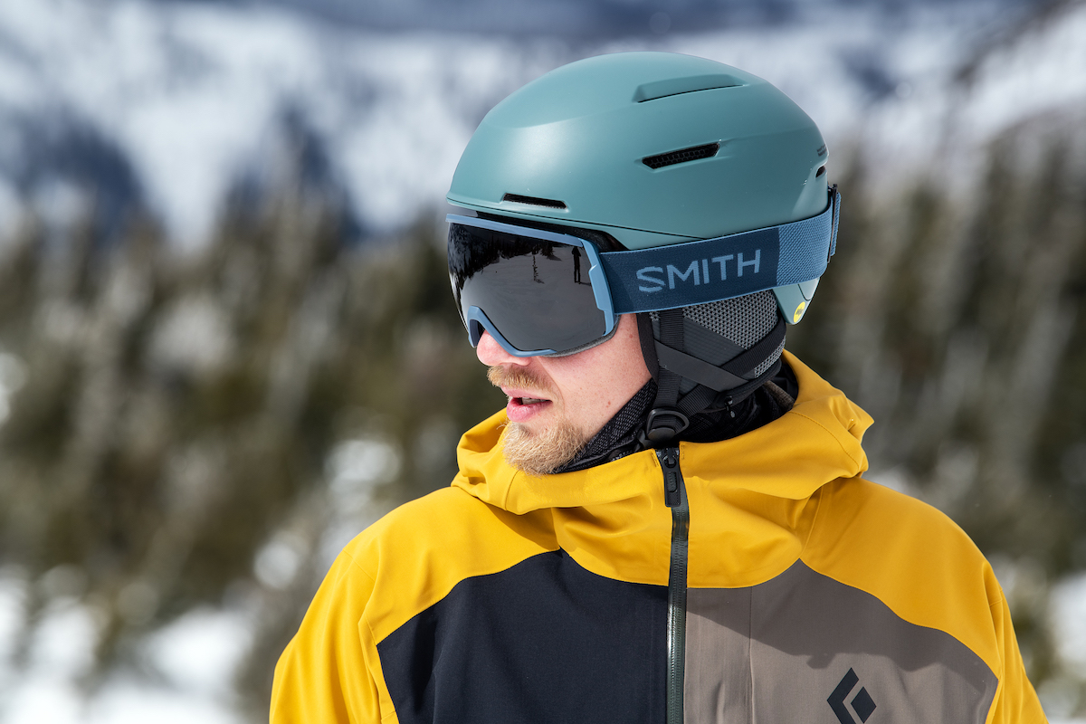 Man skier in black ski suit and goggles skiing downhill trough