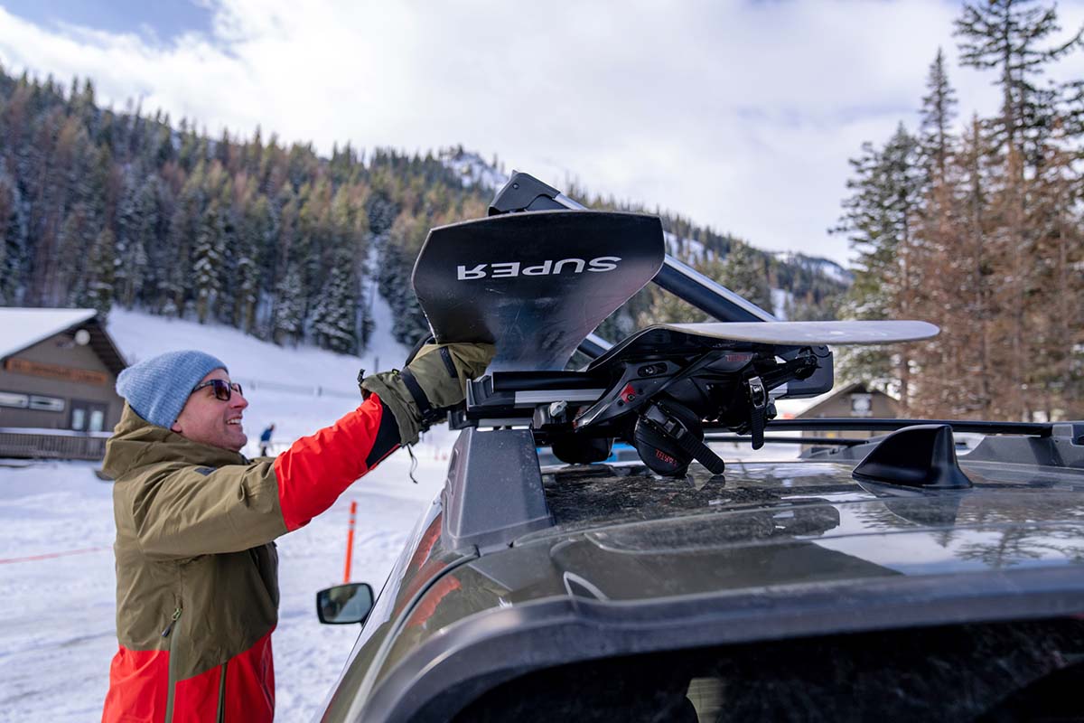 Loading a snowboard on the Thule SnowPack ski snowboard rack