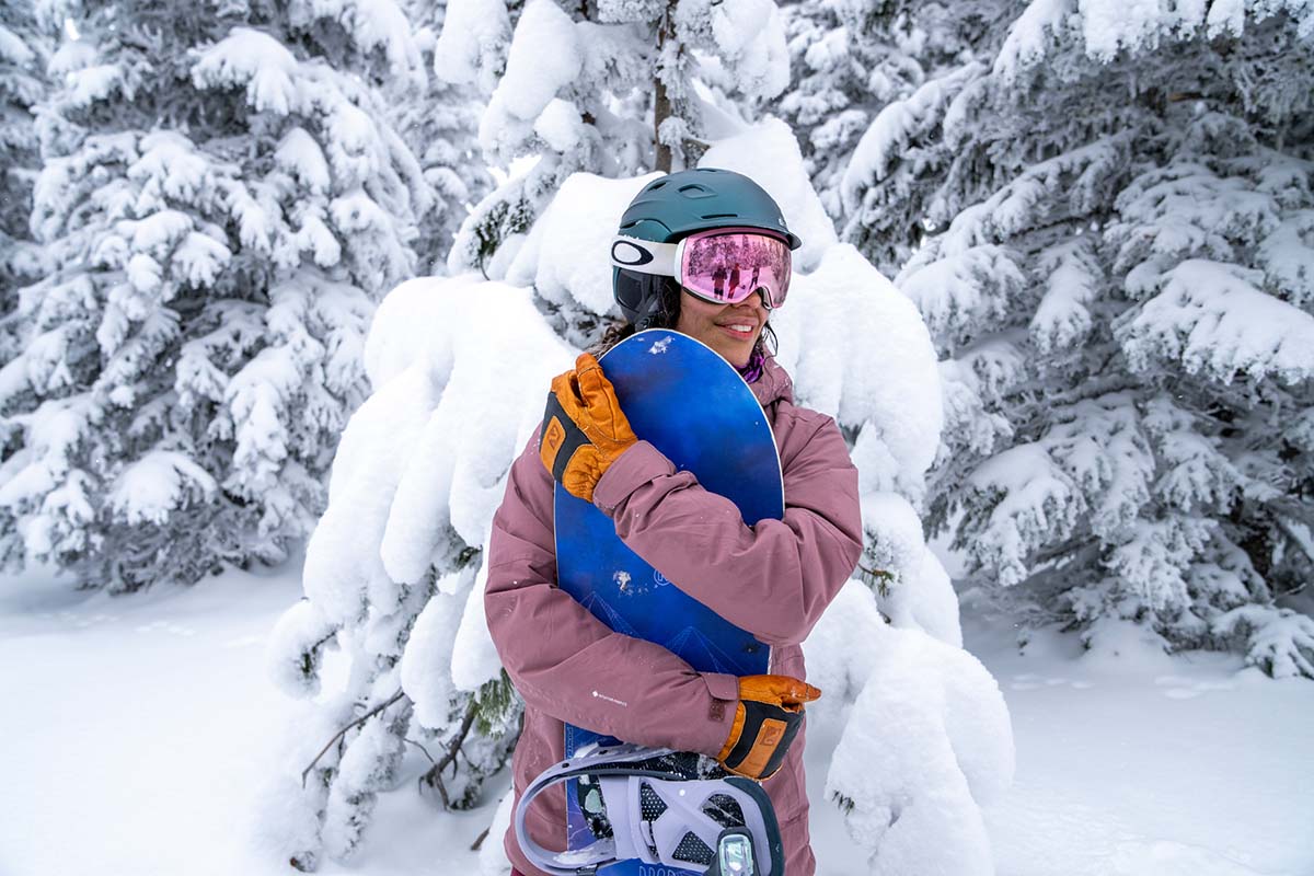 Standing with snowboard in forest