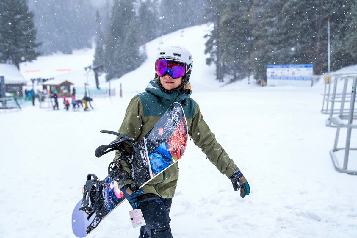 Walking in resort with snowboard (snowing)