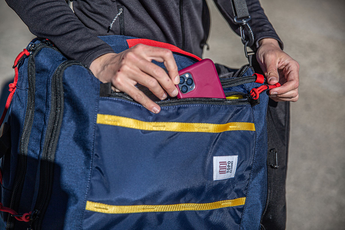 Travel backpack (pulling phone out of front pocket on Topo Designs Global Travel Bag)