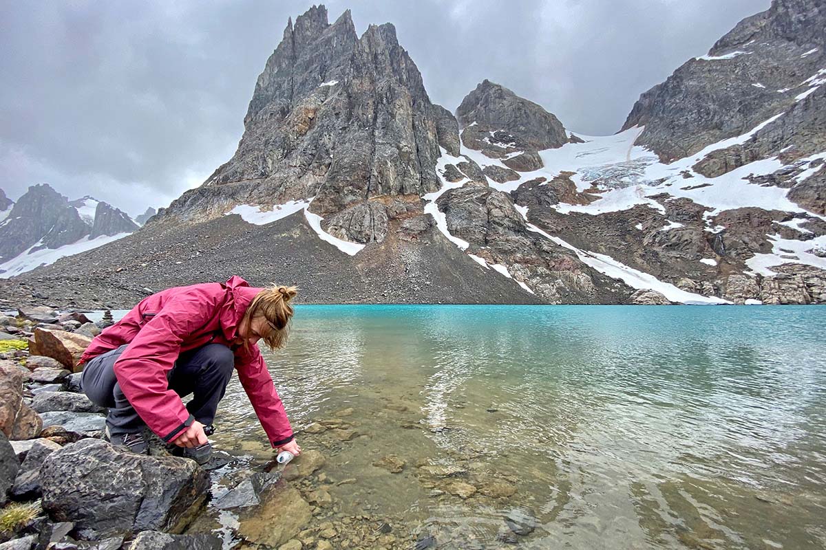 Collecting water in Patagonian lake wearing Black Diamond Liquid Point rain jacket