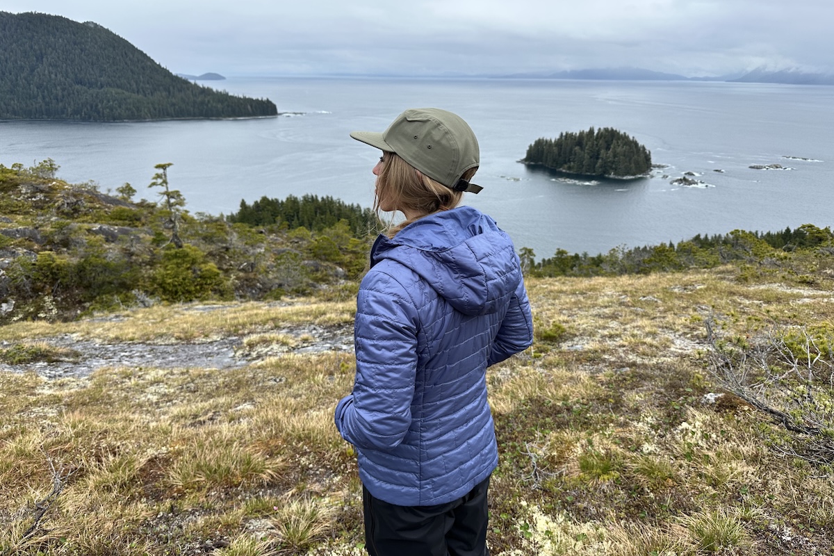 A woman overlooking the ocean while wearing the Patagonia Nano Puff Hoody