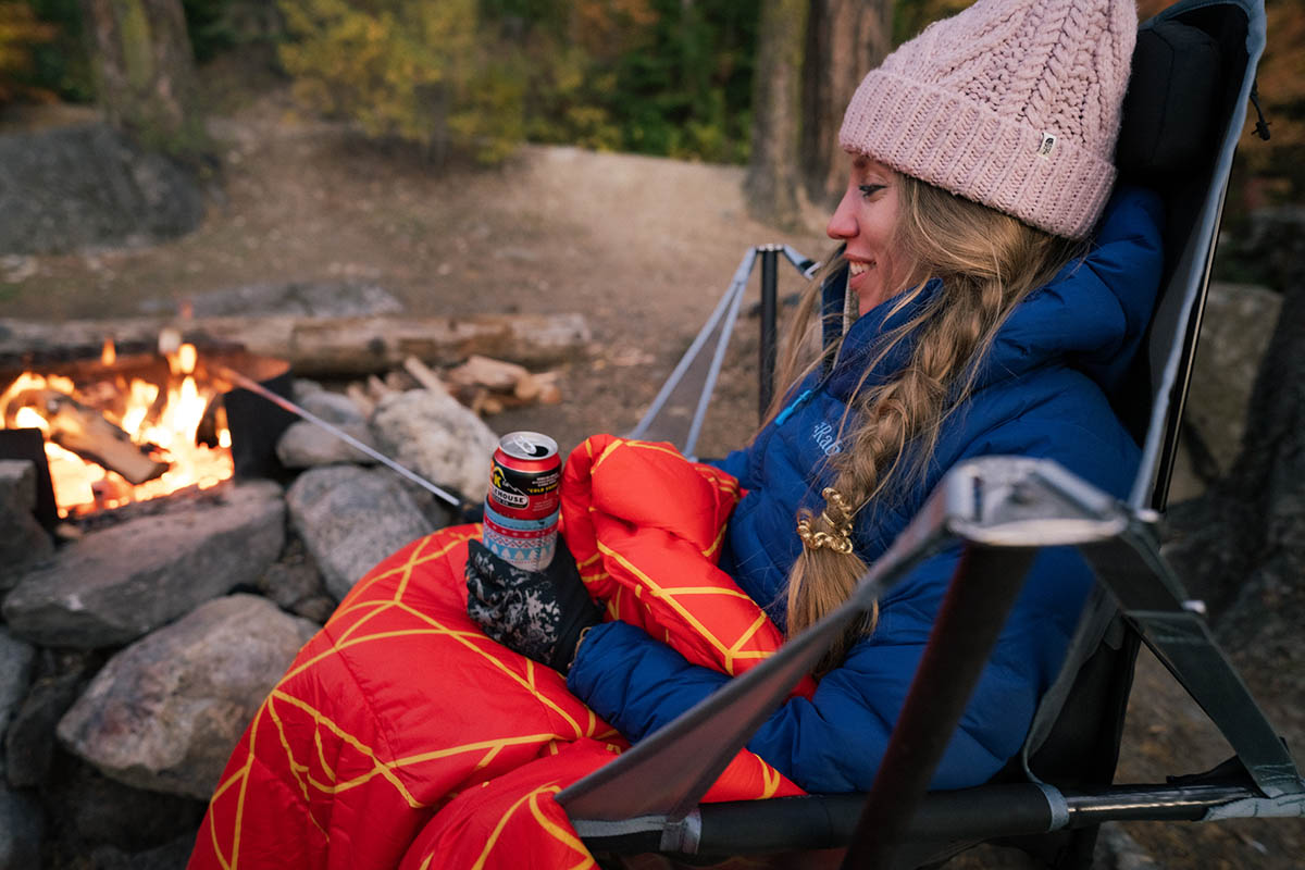 Camping checklist (sitting by campfire in down jacket with blanket)