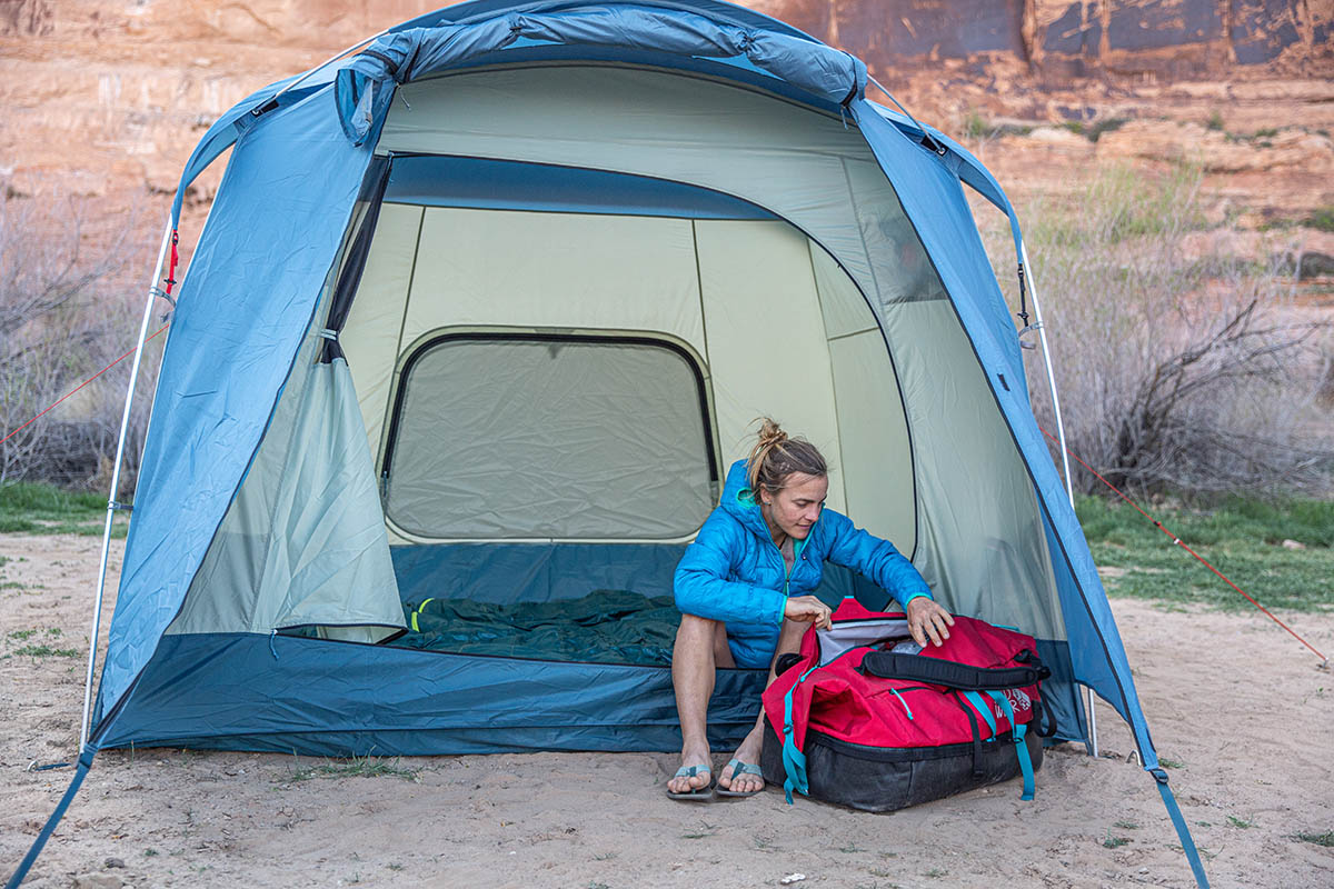 Camping checklist (sitting outside REI tent reaching into duffel bag)