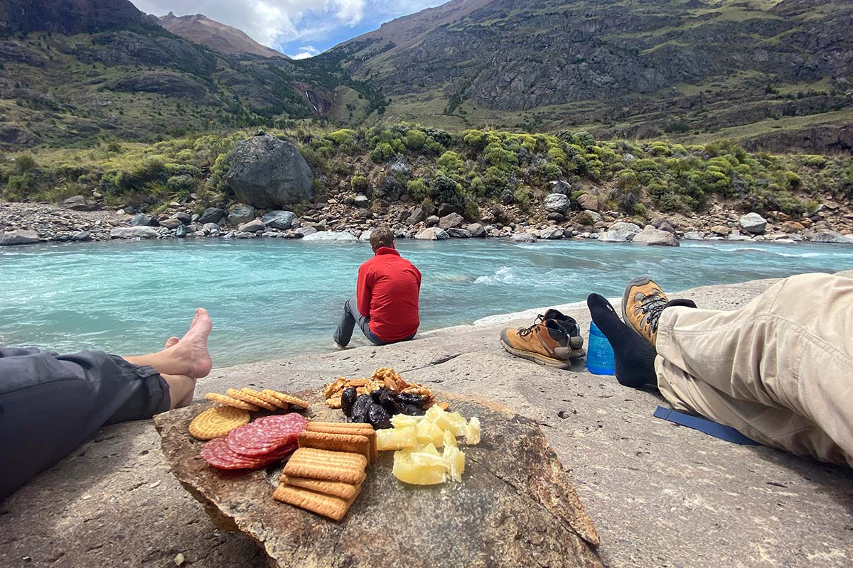 Day Hiking Checklist (eating fruit and nut snacks by river in Patagonia)