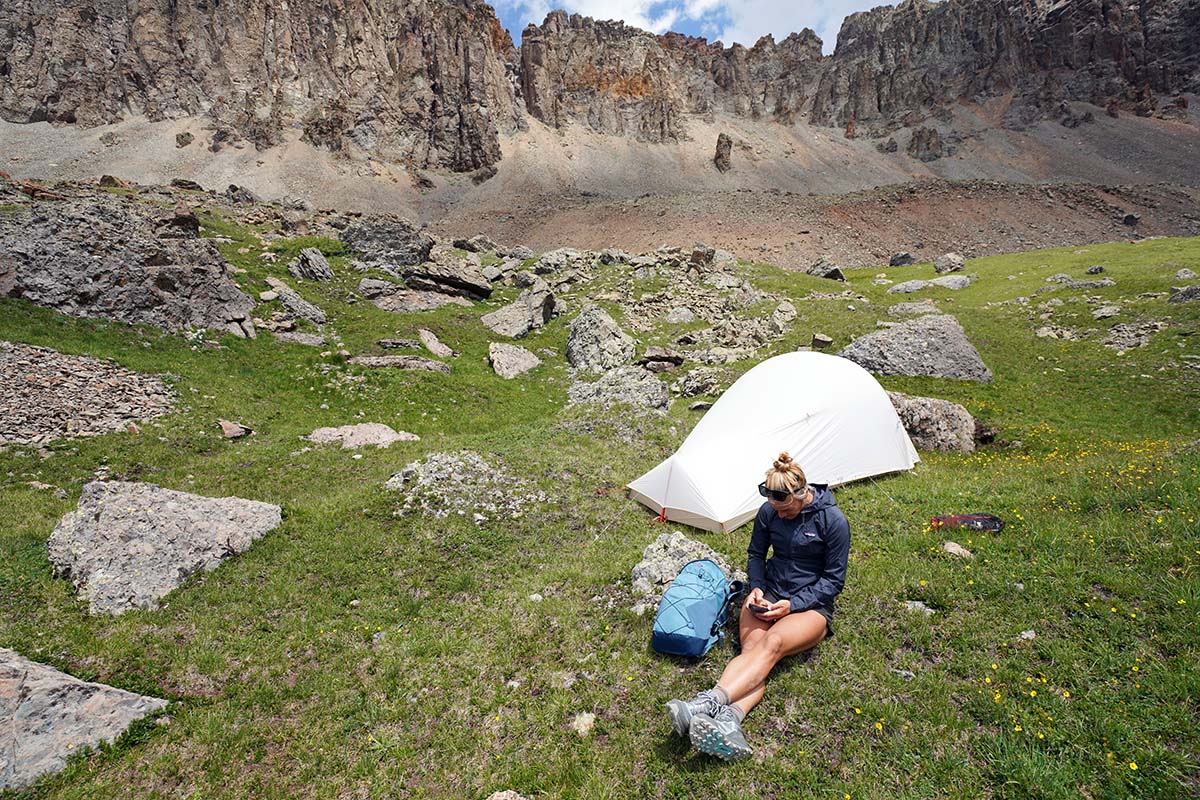 Sitting at camp using satellite messenger (Altra Lone Peak ALL-WTHR Mid hiking boot)