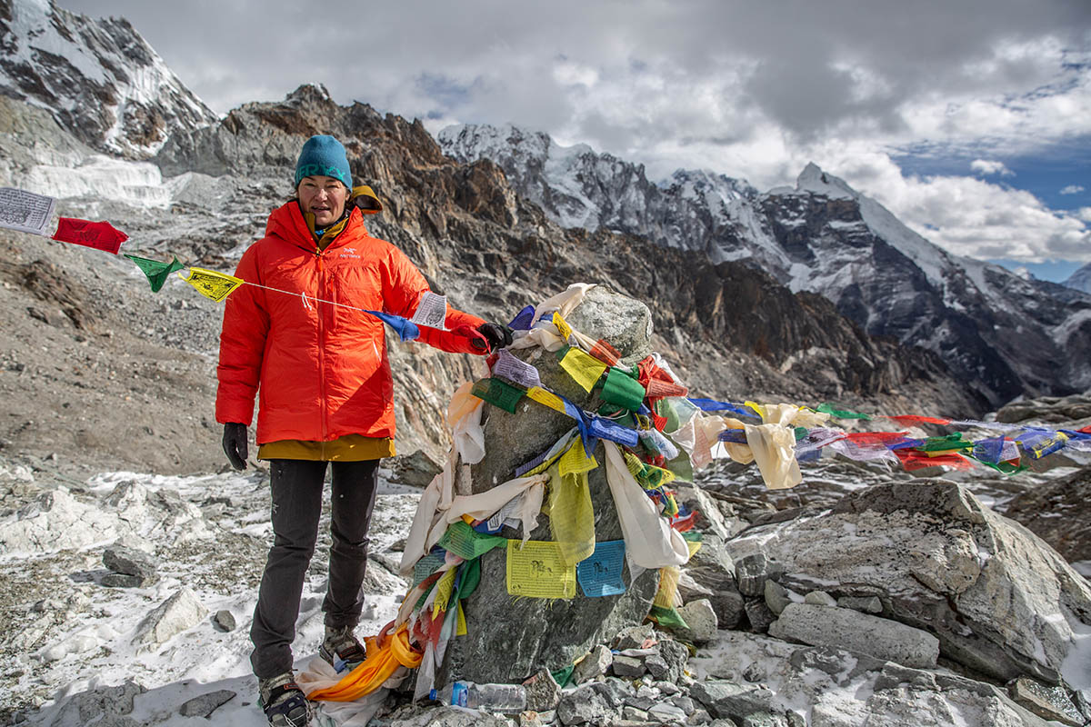 Arc'teryx Alpha Parka (standing with prayer flags in mountains)