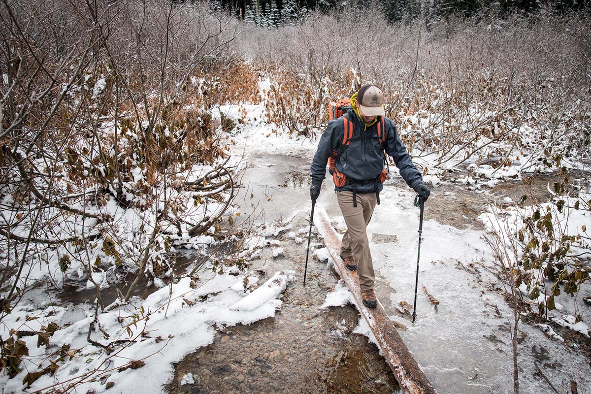 Crossing log above frozen water (wearing Arc'teryx Beta AR hardshell jacket)