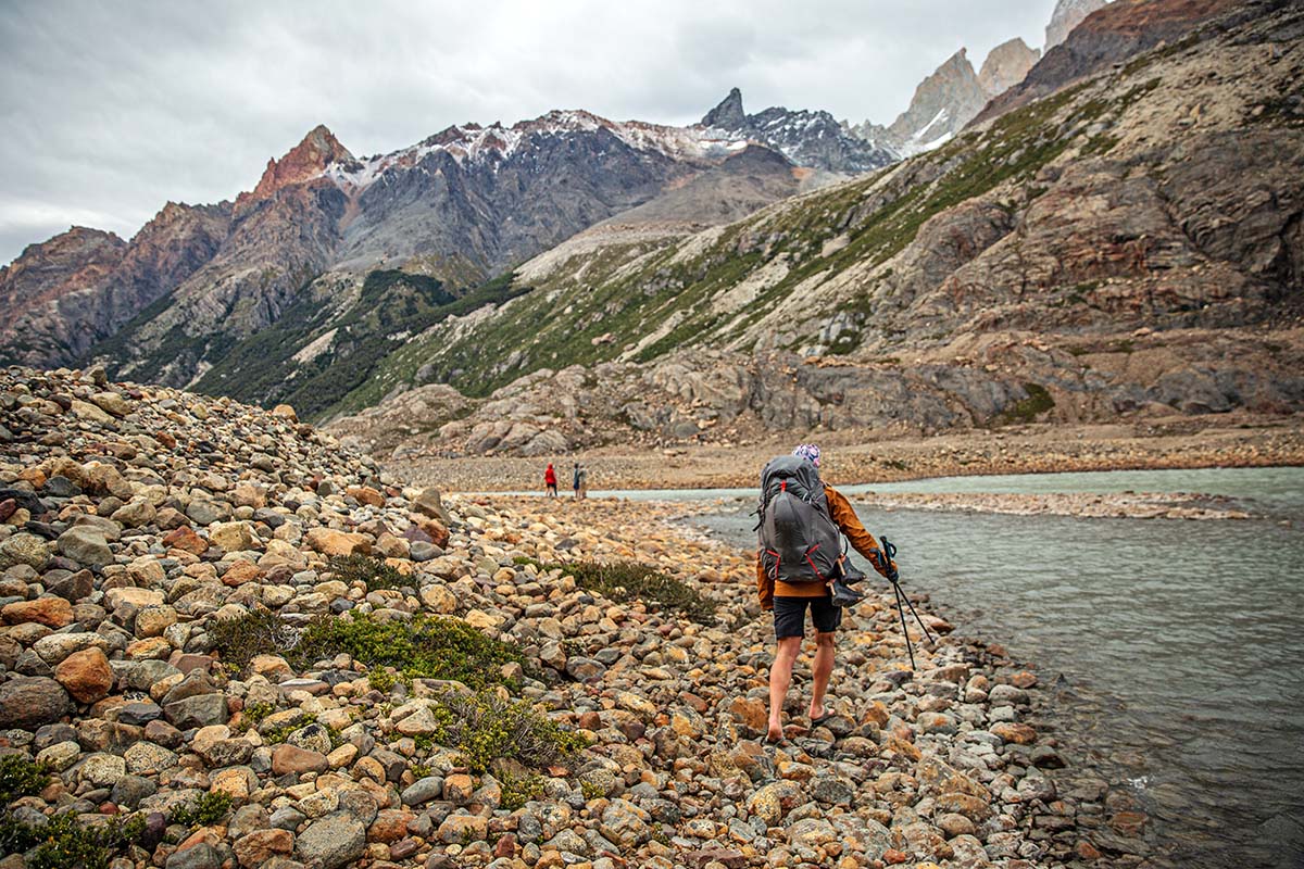 Hiking barefoot beside river in Patagonia (Fjallraven Keb Eco-Shell Jacket)
