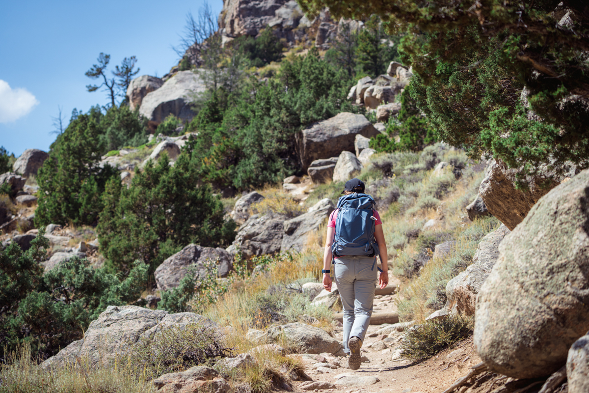 A woman hiking away on a rocky trail wearing waterproof hiking boots