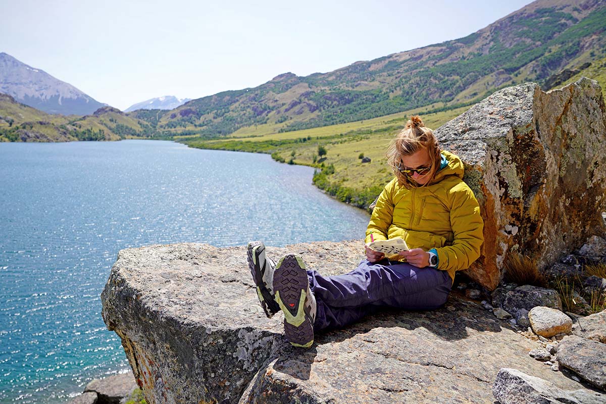 Mountain Hardwear SuperDS Stretchdown Hooded jacket (sitting on rock)