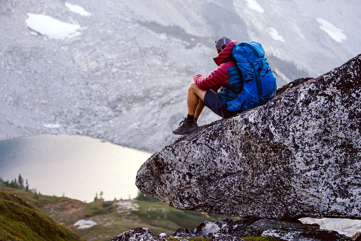 Patagonia Down Sweater Hoody (sitting on rock)