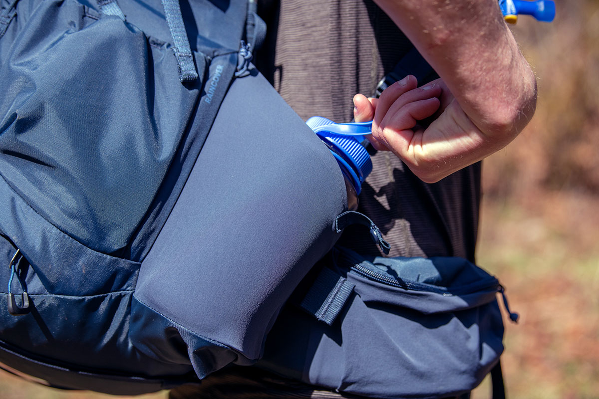 REI Co-op Traverse 60 backpack (reaching for water bottle)