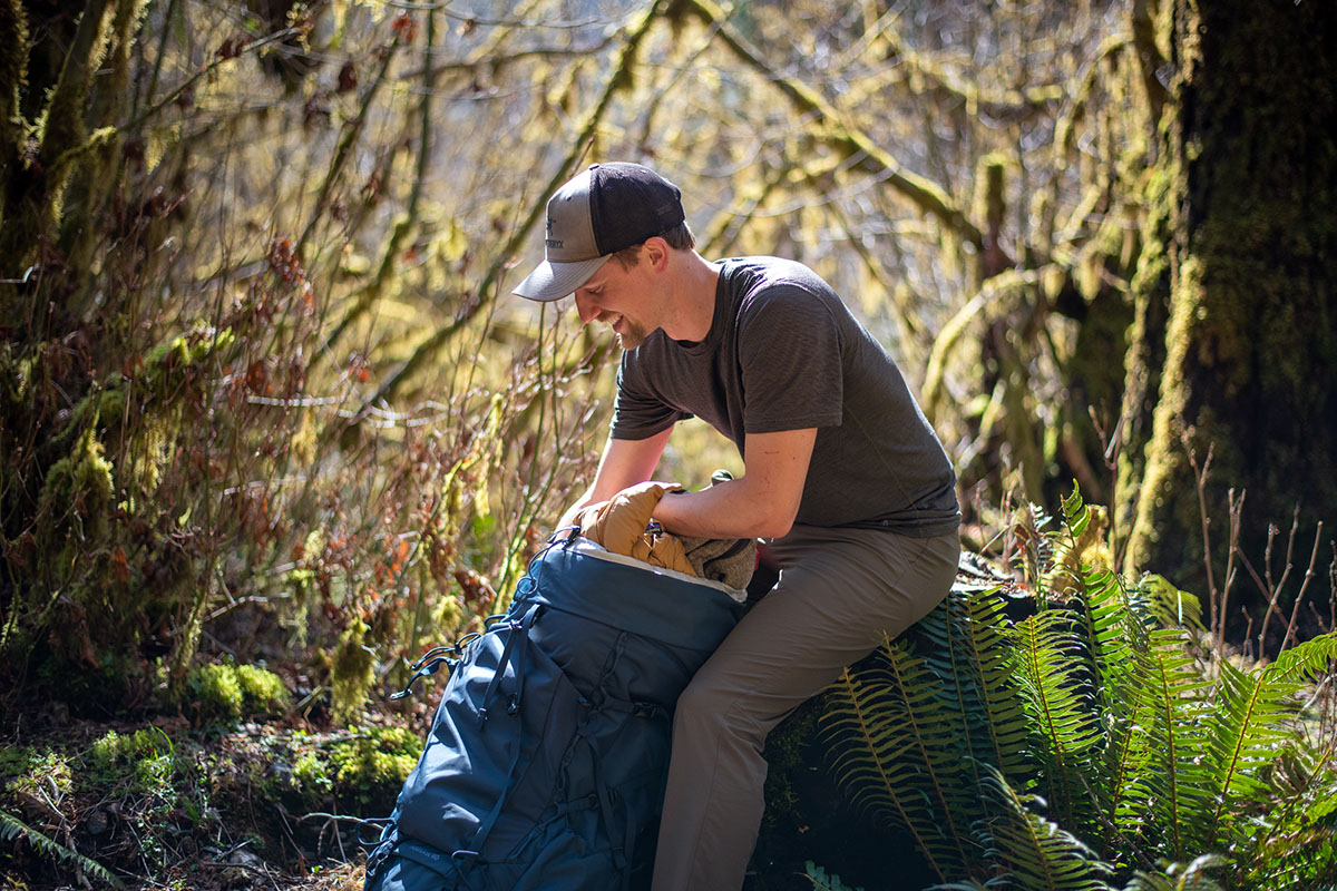 REI Co-op Traverse 60 backpack (reaching into main compartment)