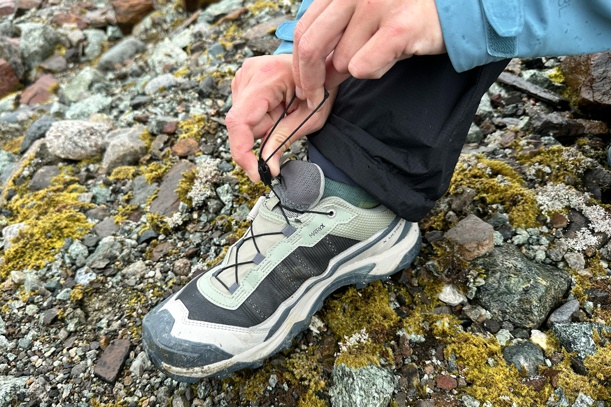 Hands pulling on the Quicklace system on the Salomon X Ultra 5 GTX hiking shoe