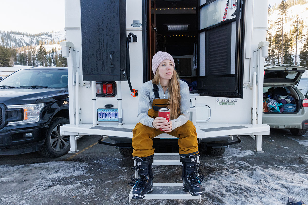 Trew Gear Astoria ski bib (sitting on steps of camper)