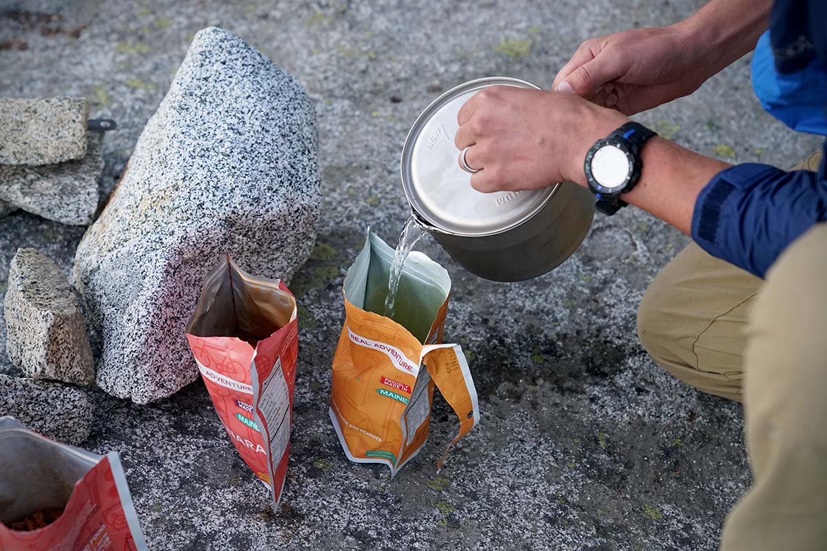 Pouring water into dehydrated meal (How to Choose a Backpacking Stove)