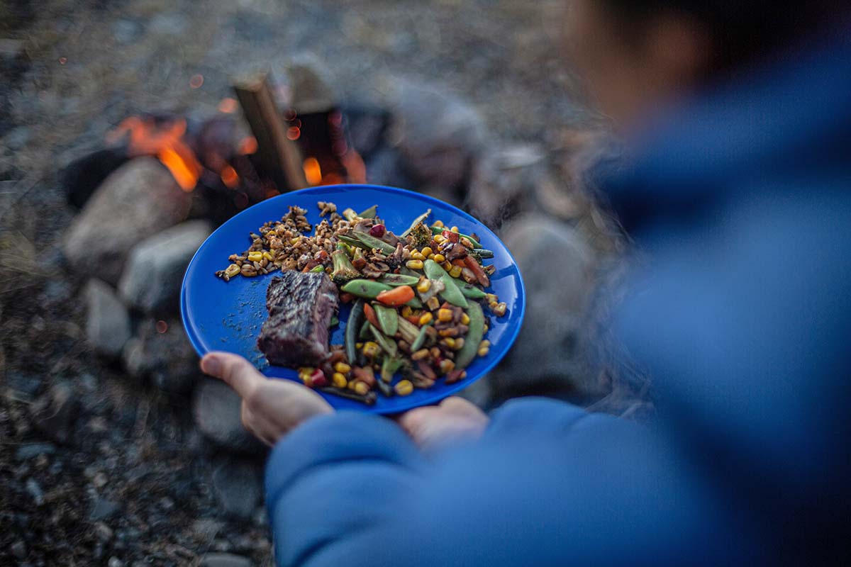 Eating camp dinner by fire