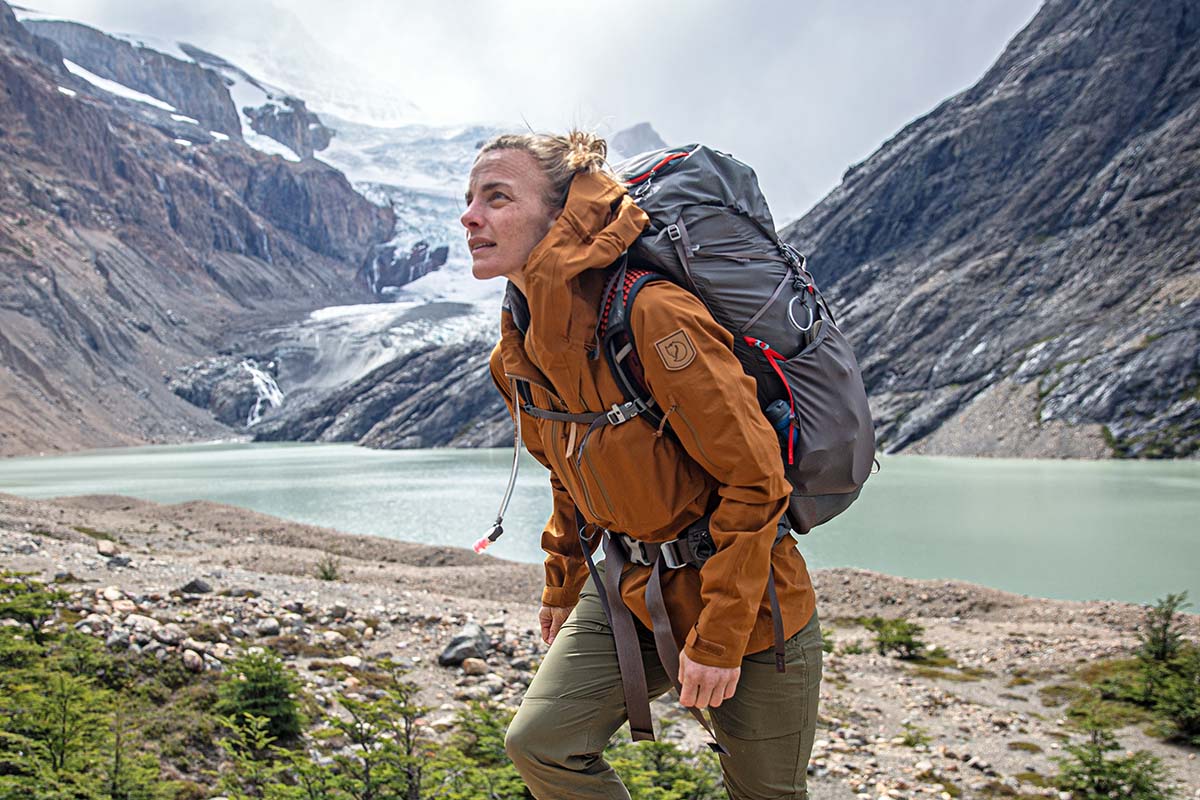 Jenny walking up from lake with backpack