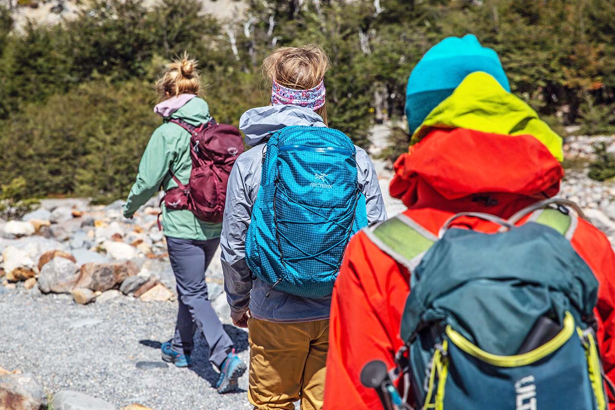 Three women hiking together down trail