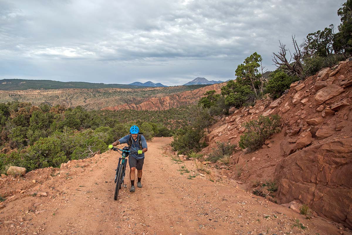 Walking bike uphill on dirt road