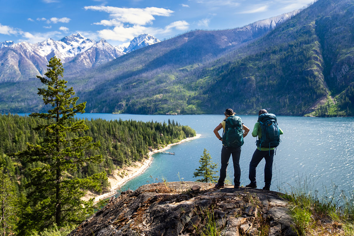 REI 4th of July Sale (standing above lake with backpacks)