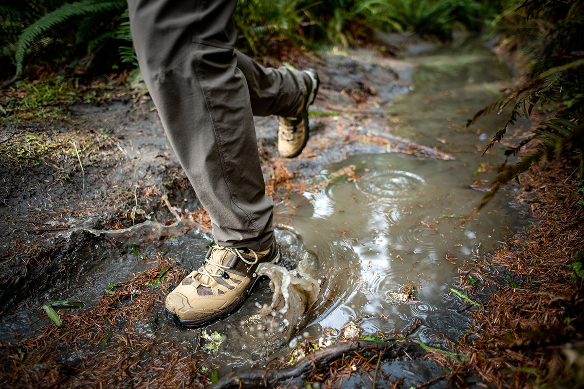 Salomon hiking footwear (Quest 4 GTX splashing through puddle)