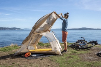 Setting up the big agnes tiger wall bikepack tent next to some water