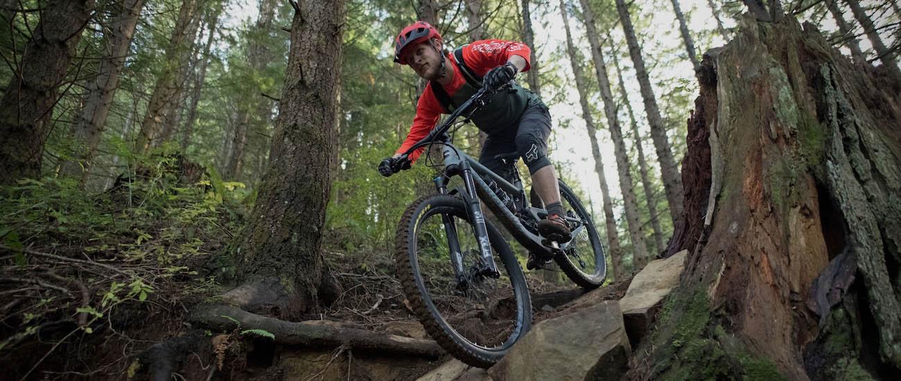 The Santa Cruz Bronson mountain bike coming downhill over some rocks