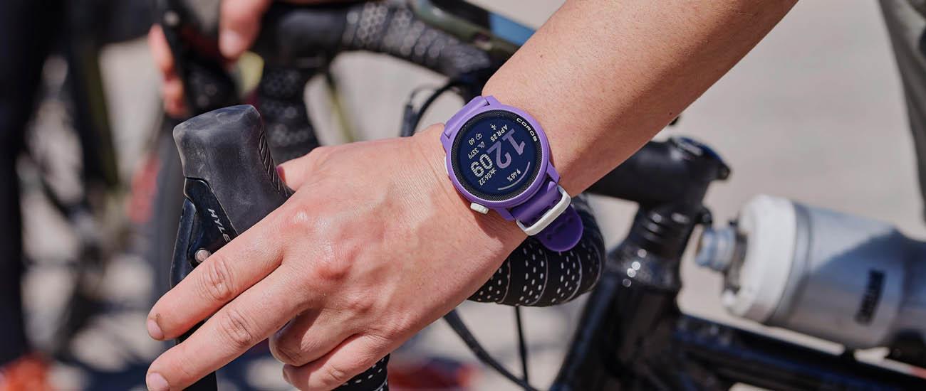 A close up of a wrist on bike handlebars wearing the Coros Pace 3 watch