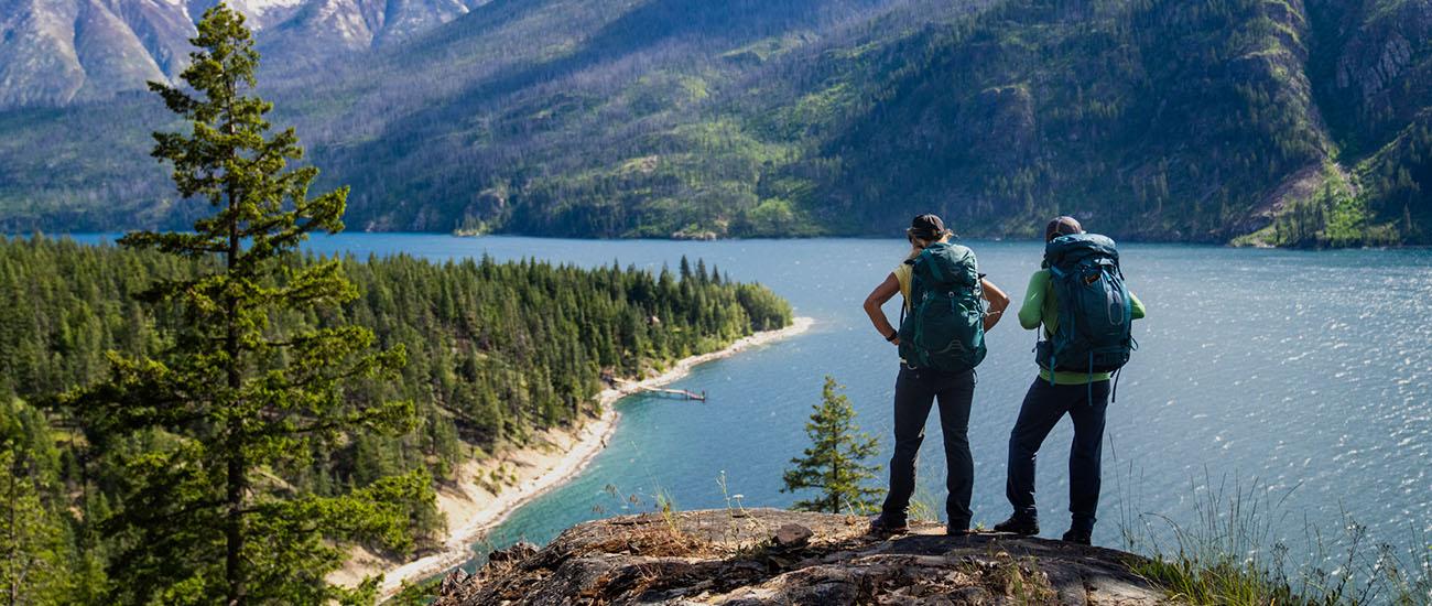 REI 4th of July Sale (standing above lake with backpacking gear)