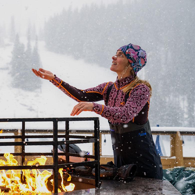Women's baselayer (standing by fire at lodge in Kari Traa Rose Half-Zip)