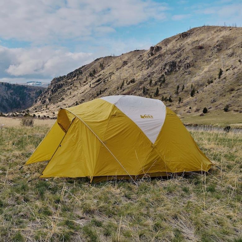 Setting up the Base Camp 6 tent in a field in the Montana wilderness