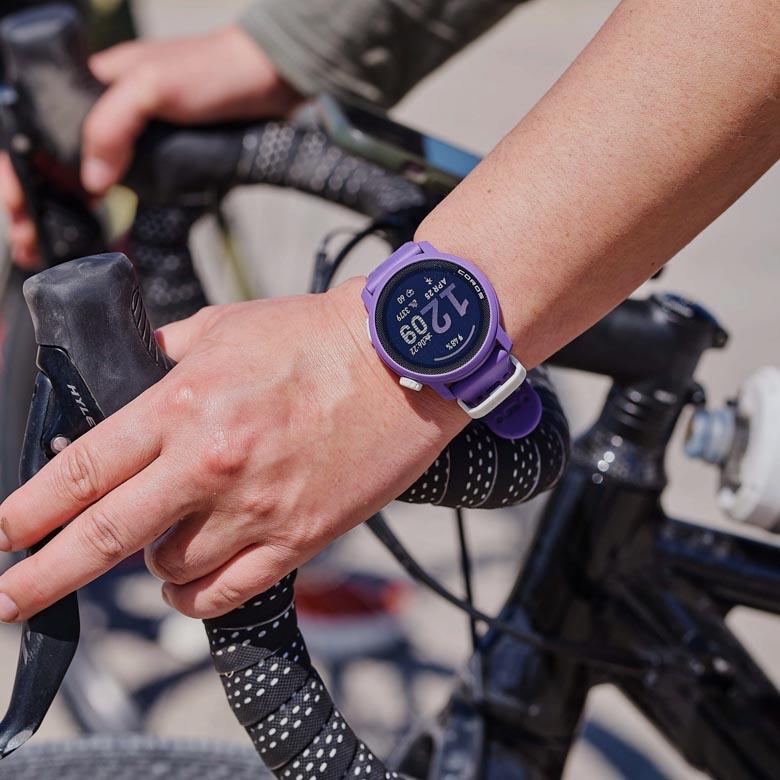 A close up of a wrist on bike handlebars wearing the Coros Pace 3 watch