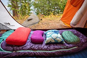Camping and backpacking pillows (lined up on sleeping bag)